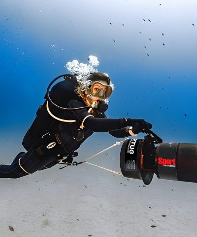 Taucher nutzt den DiverTug Sport Unterwasser-Scooter während eines Tauchgangs im offenen Meer.