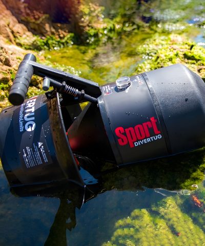 DiverTug Sport liegt nass im flachen Wasser und zeigt Gehäuse, Griff und Düse im Outdoor Einsatz.